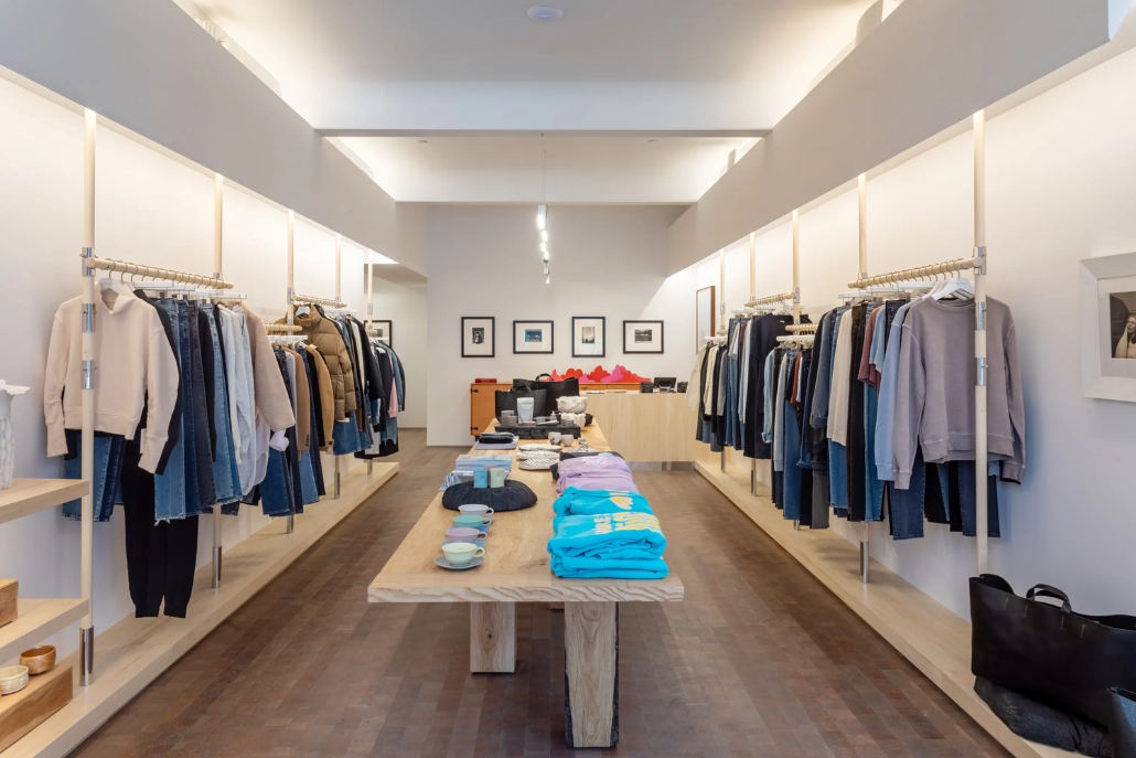 A clothing store interior with racks of Aspen Style tailored denim jeans set against a warm wooden floor.