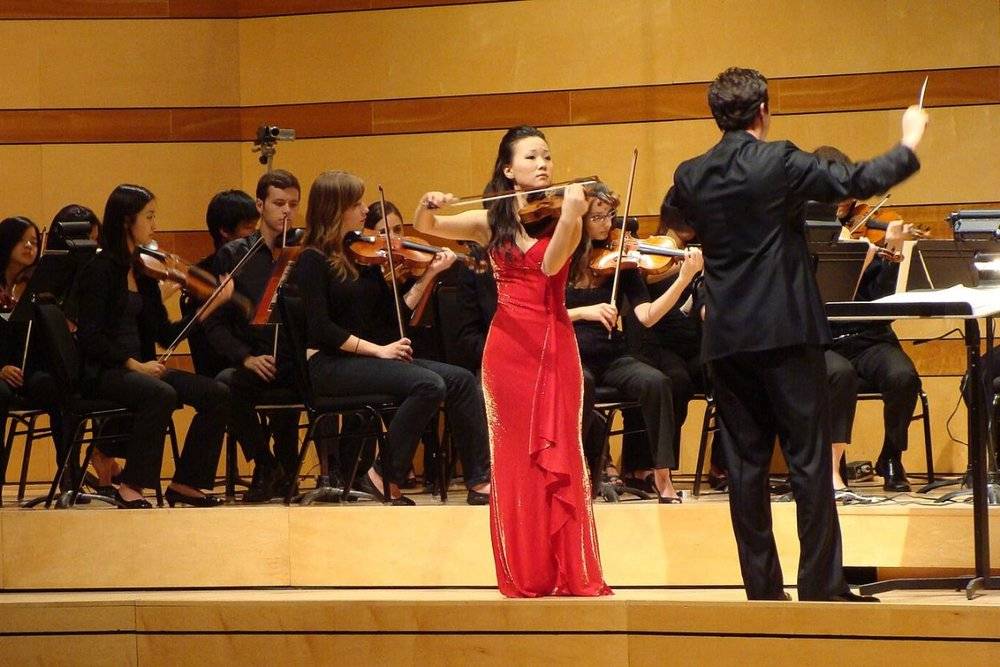 The conductor is coordinating all musicians to perform the performance at the Aspen Music Festival