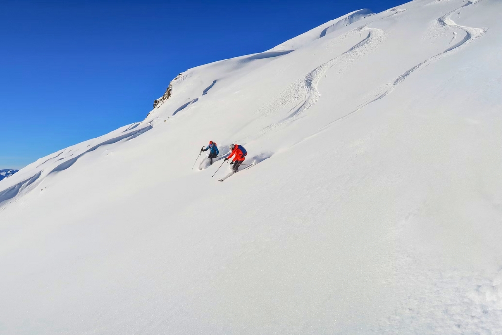 Two people navigate a snow-covered mountain while skiing at Aspen Highlands, capturing the thrill of winter sports in Colorado.