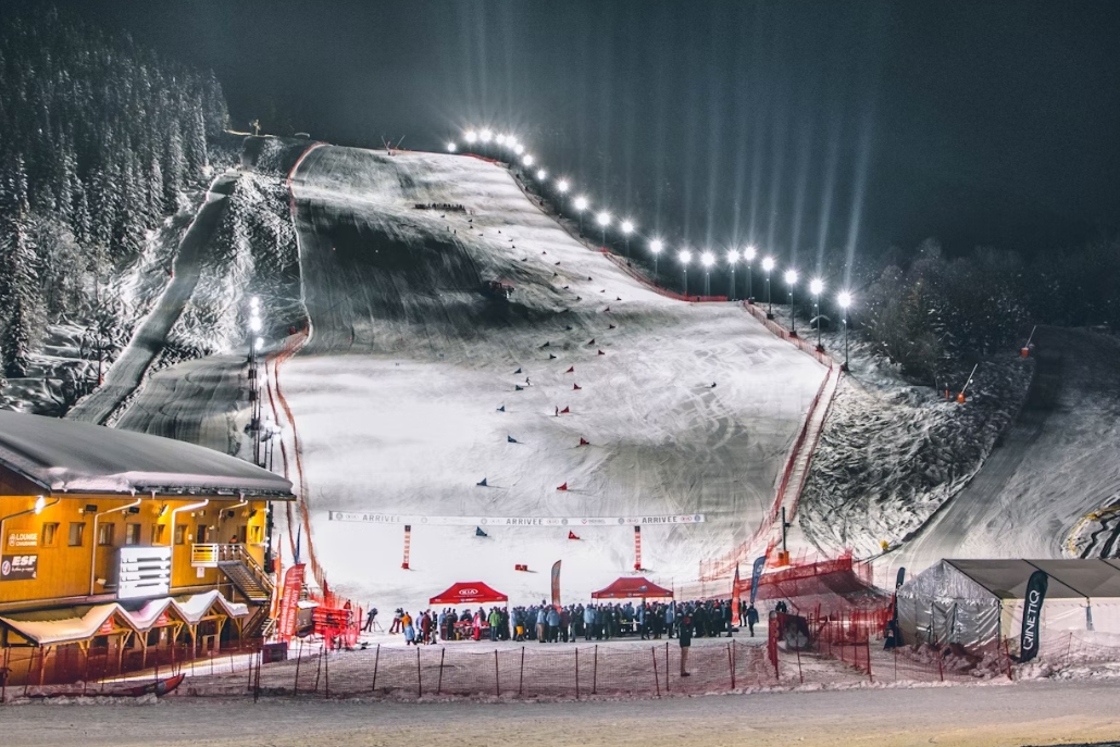 A ski slope aglow with lights at night, capturing the lively spirit of fan engagement during the X Games Concerts.
