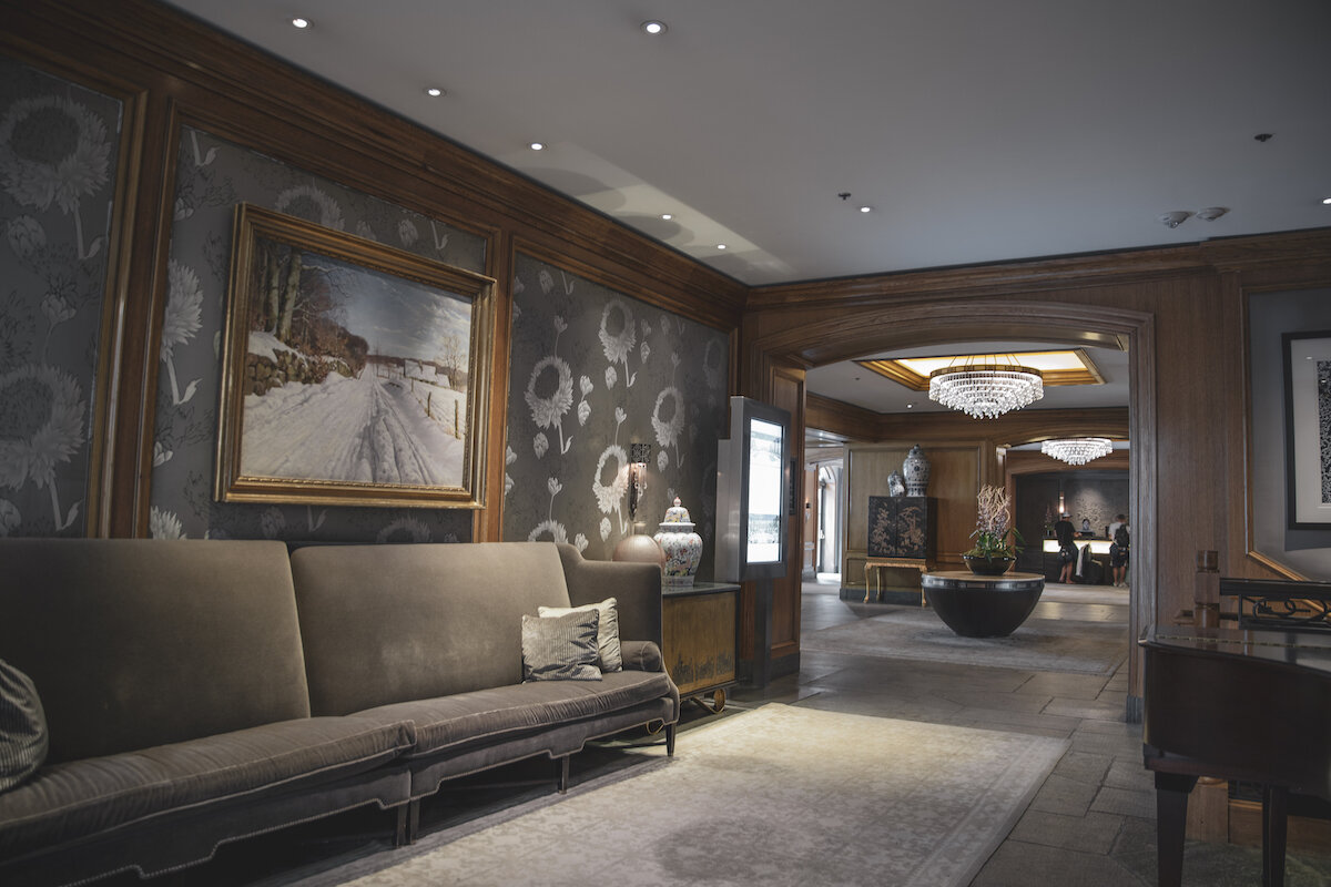 The inviting living room of St. Regis Aspen Resort showcases a comfortable couch and a beautiful painting.