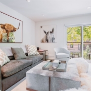 A cozy living room featuring a comfortable couch, and a vibrant cow painting on the wall, creating a warm atmosphere.