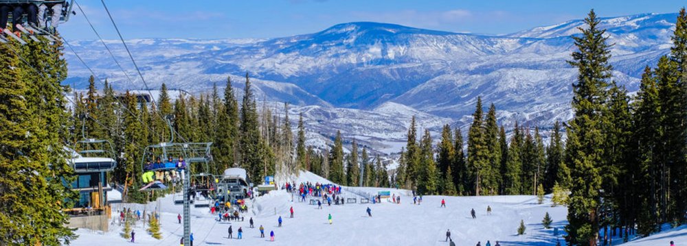 A ski lift ascends a snowy mountain, showcasing the beauty of Aspen Altitude in winter.