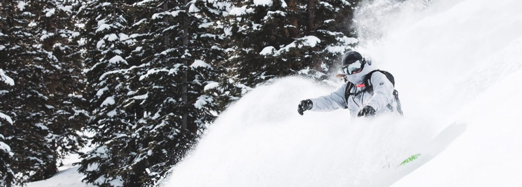 A snowboarder gracefully descends a snowy slope at Aspen Colorado Ski Resorts, showcasing winter sports excitement.