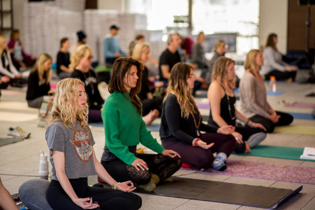 A group of women practicing yoga in retreat, with the Founder Gina Murdock