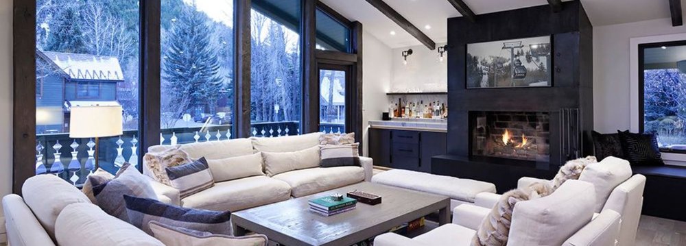 A cozy living room featuring plush couches and a warm fireplace, ideal for Aspen Luxury Vacation Rentals.