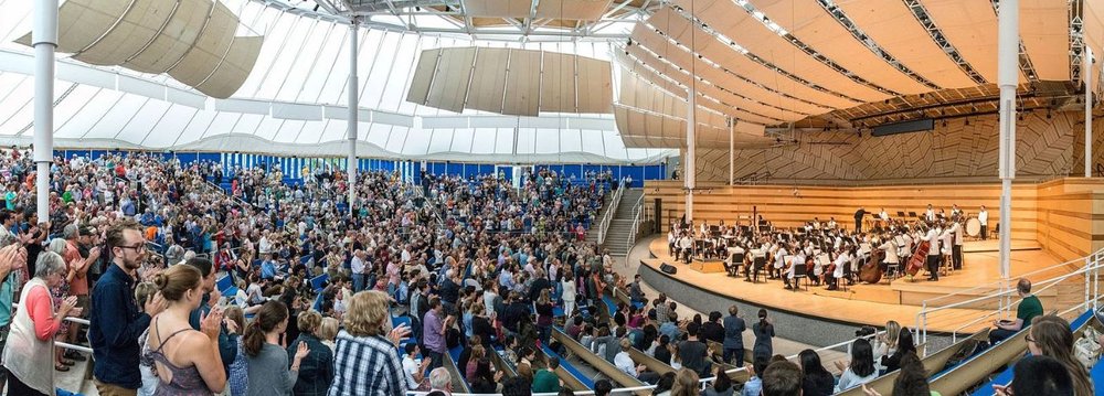 A large crowd gathers in a spacious auditorium during the Aspen Music Festival event.