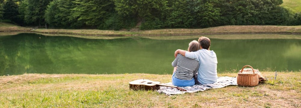 A couple enjoys a serene picnic in the park, surrounded by nature