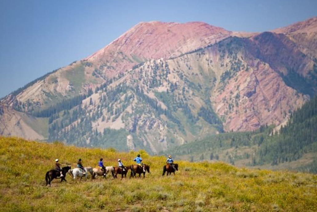 A group of hikers visit the mountains on horseback