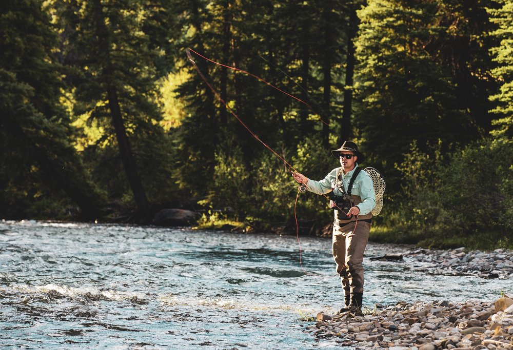 A man fly fishing in aspen in summer