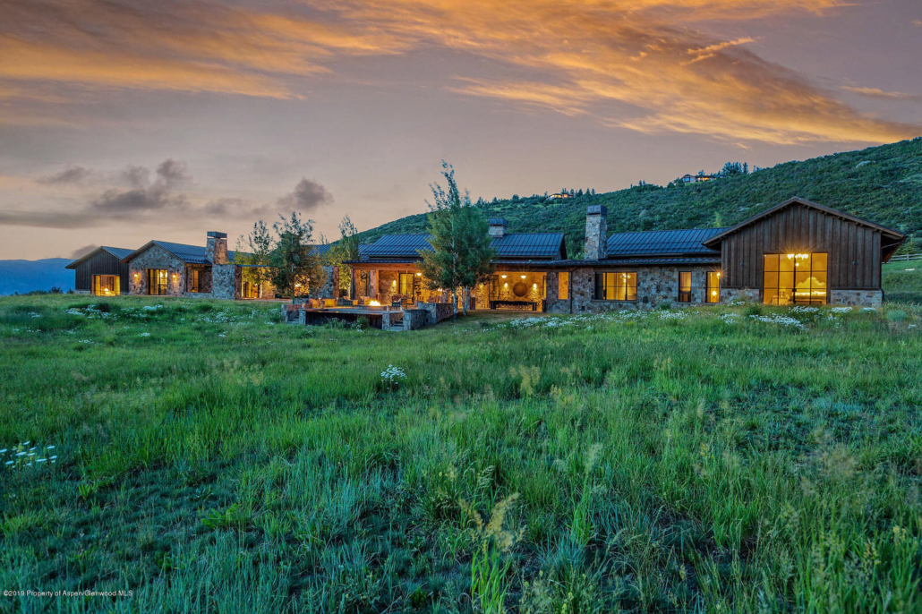 One of the Aspen neighborhoods remote villa edition, illuminated by a vibrant sunset, showcasing serene surroundings.