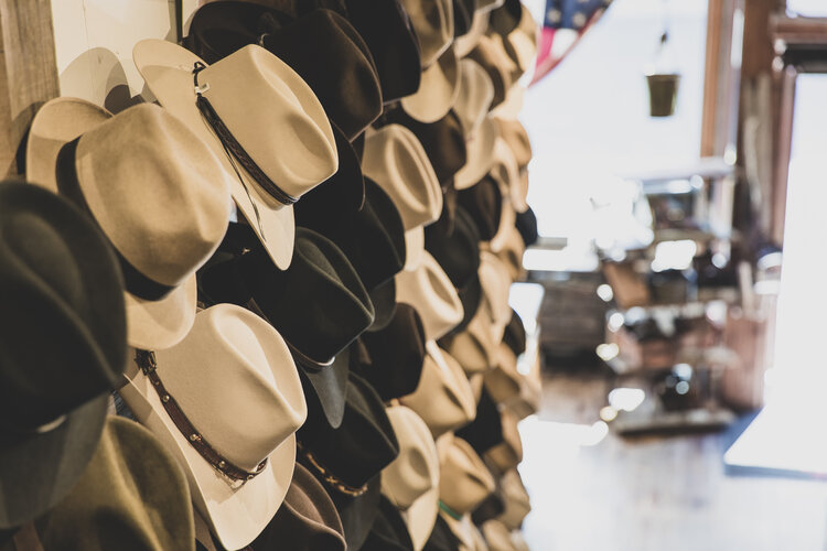 A variety of hats displayed on a wall in a store, showcasing diverse styles and colors.