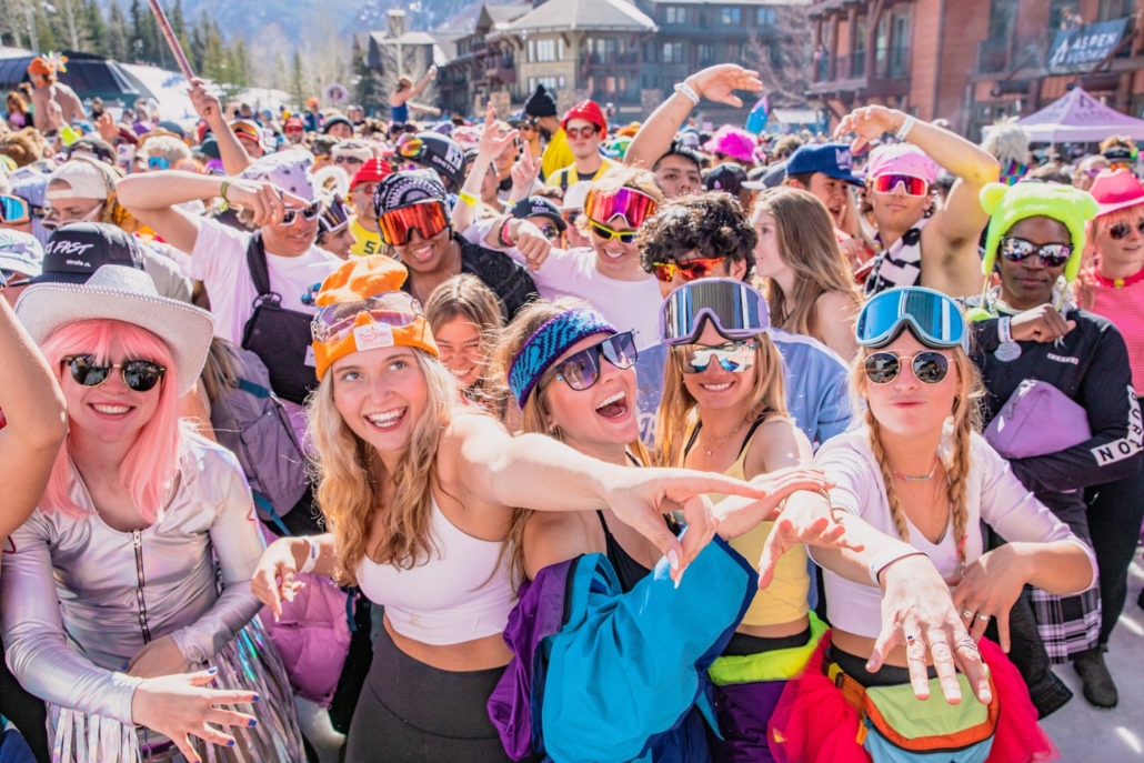 A lively group of individuals in colorful hats and sunglasses enjoying Ski events in Aspen