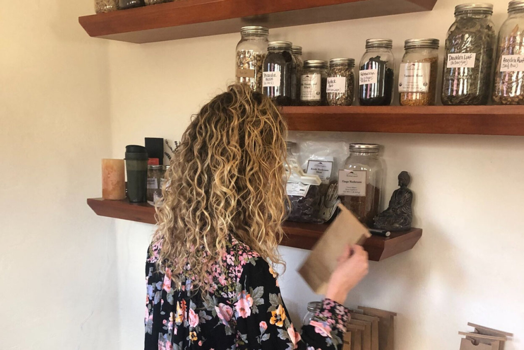 Brittany Buffalino stands in front of shelves filled with various jars, showcasing her interest in medical preservation.