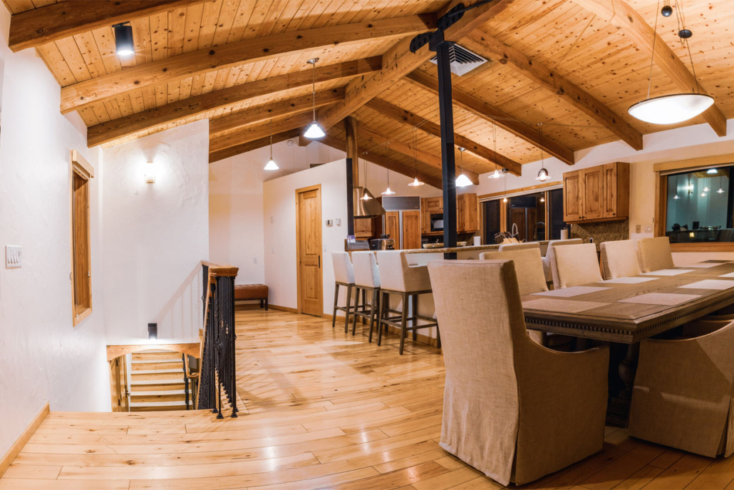 An expansive kitchen and dining space adorned with wooden beams, creating a warm atmosphere.