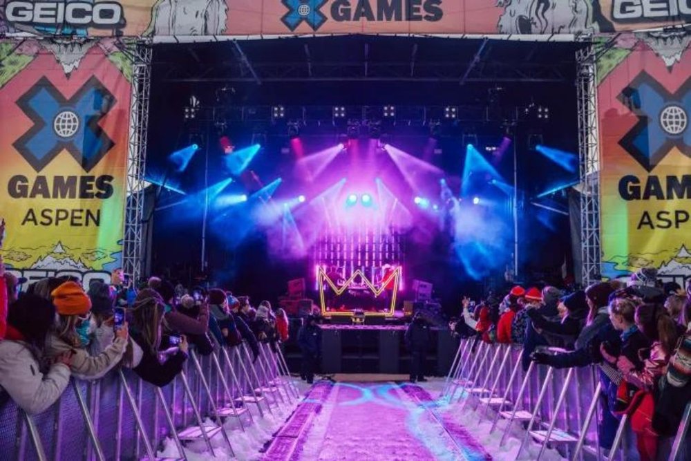 A very famous artist is playing a pop song for his fans at the x games concert in aspen