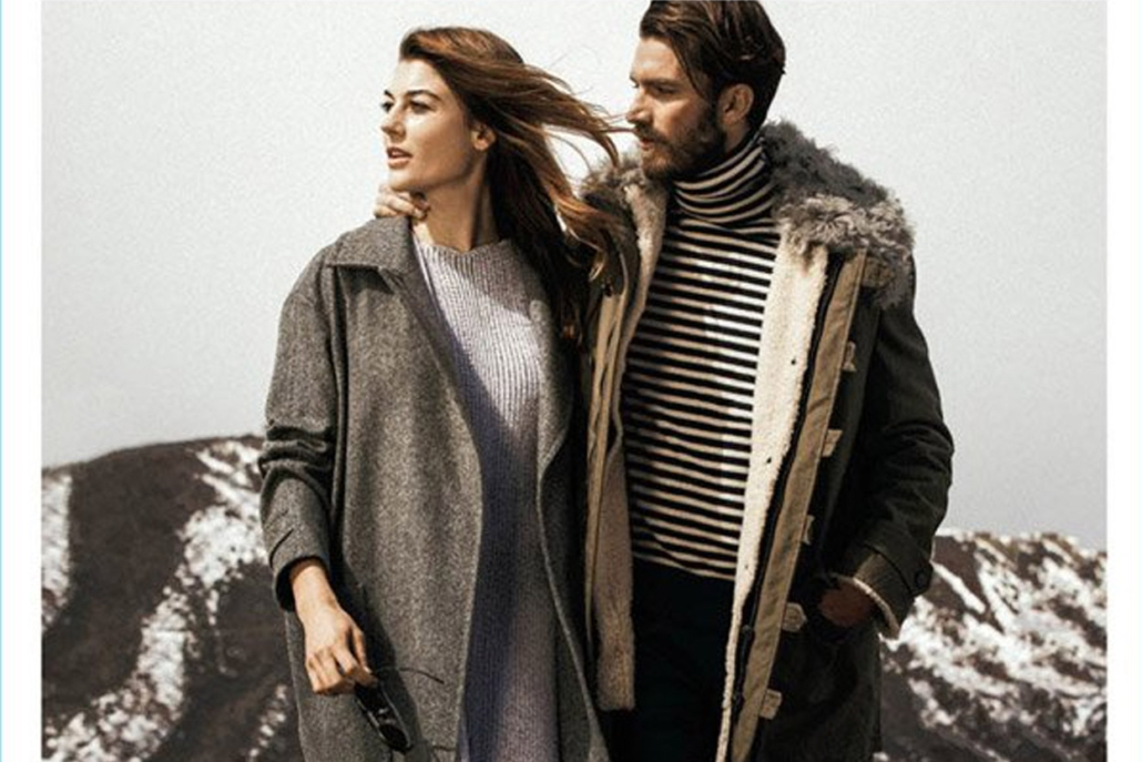 A man and woman in stylish coats stand together, showcasing Aspen Style in a winter setting.