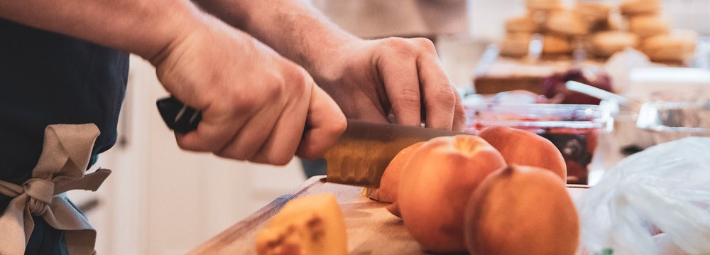 The personal chef skillfully chopping various fruits on a cutting board for Aspen Thanksgiving preparations.