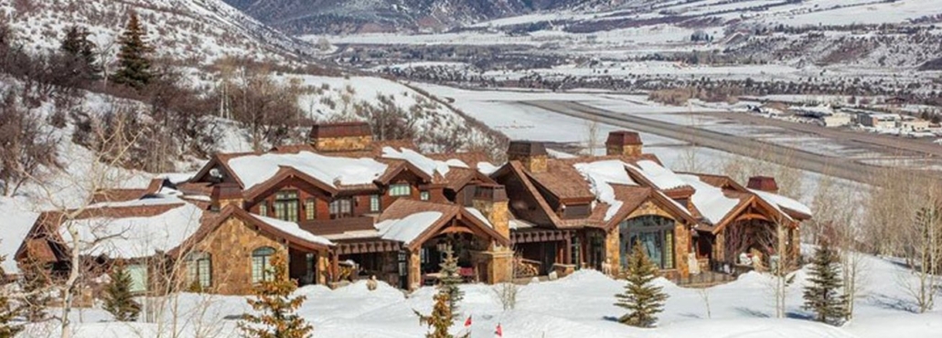 A spacious residence situated on a snowy mountain slope, surrounded by a tranquil winter scene.