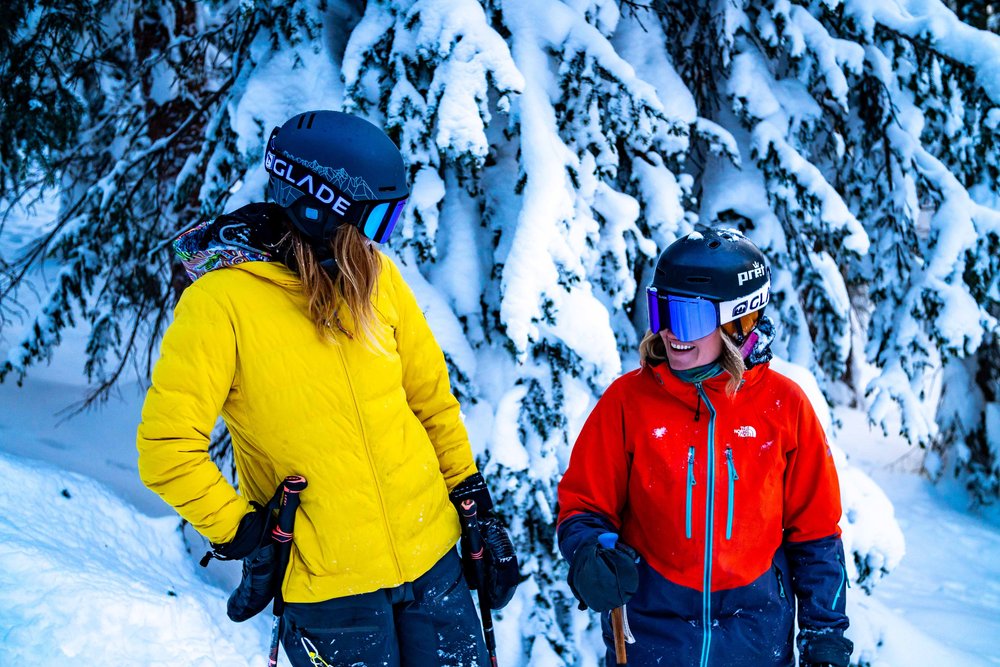 Two women skiers stand and enjoying a snowy weather in Aspen.