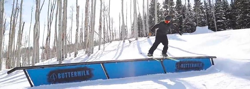  A snowboarder performs a trick on a rail, showcasing skill and style in Aspen