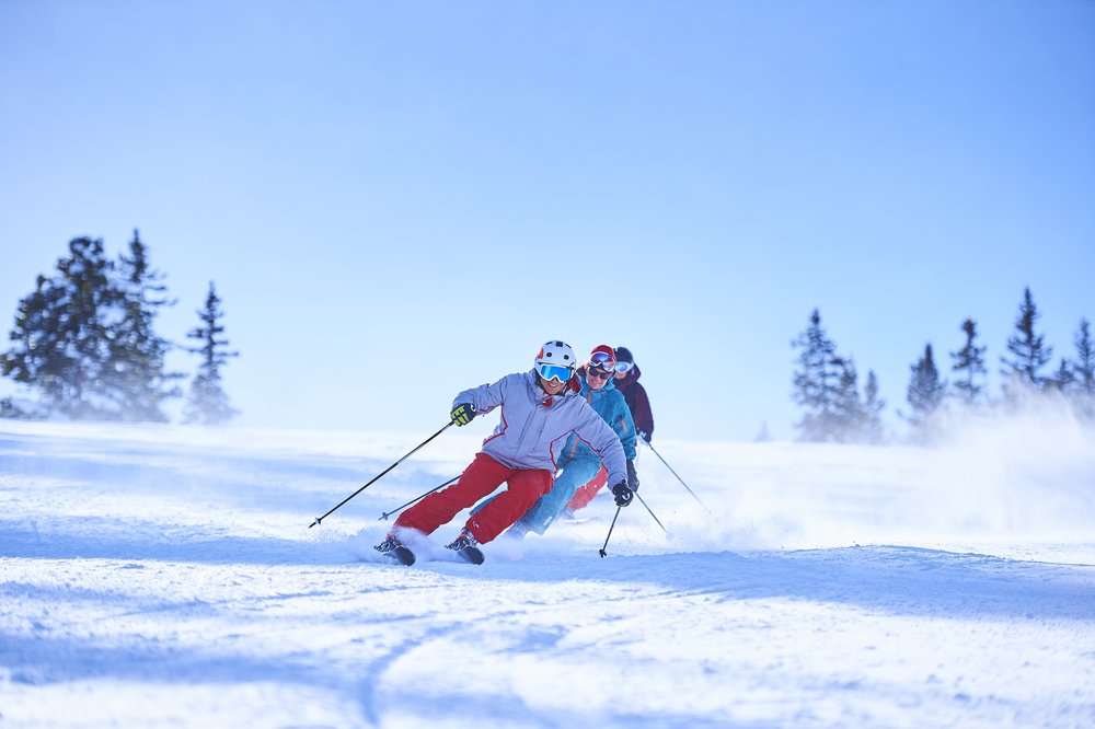 A group of skiers navigate a snowy slope, enjoying a winter adventure together in Aspen.