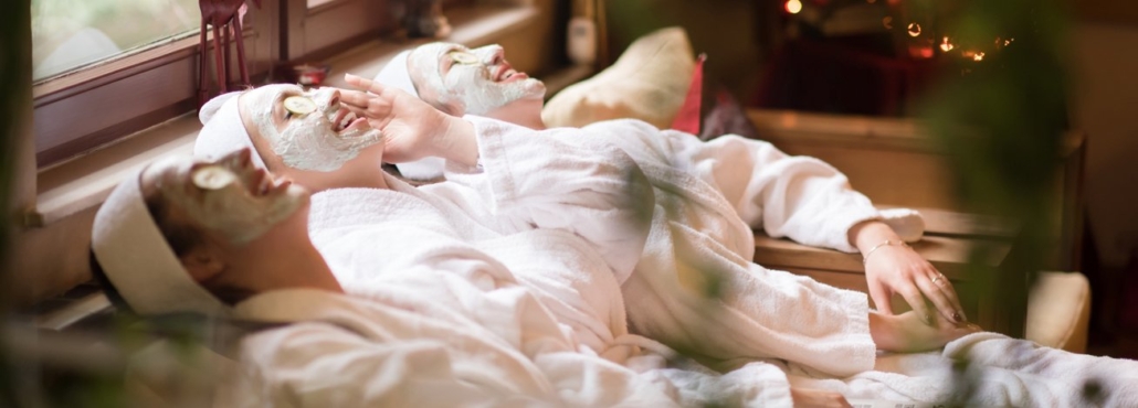 A group of women in white robes relaxing together on a spa, enjoying a moment of friendships and relaxation.