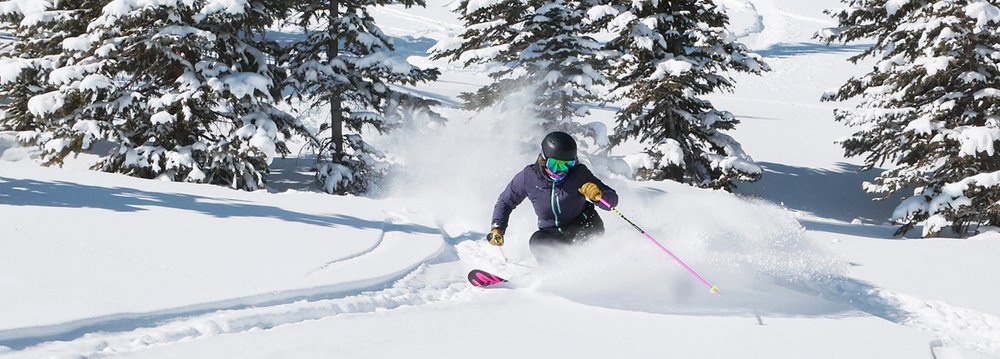 A skier gracefully descends a snow-covered slope, embodying the spirit of Aspen