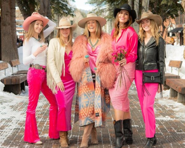 Group of women in pink outfits and Aspen Hats pose together for a cheerful group photo.