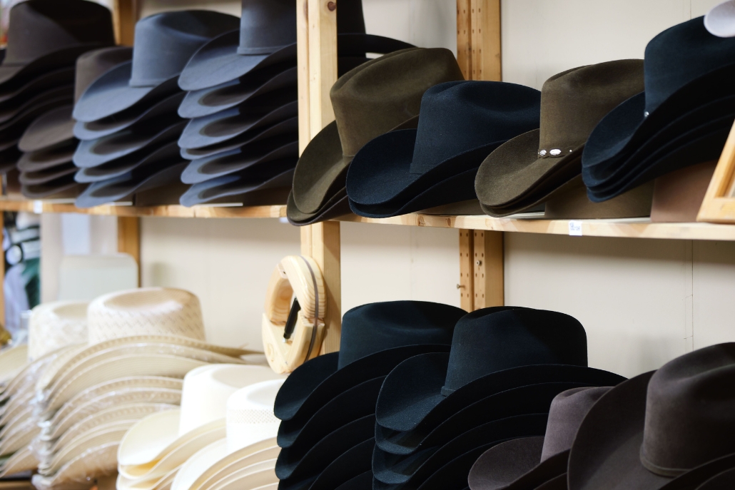 A collection of hats neatly arranged on a shelf, showcasing Aspen Hats by Nick Fouquet.