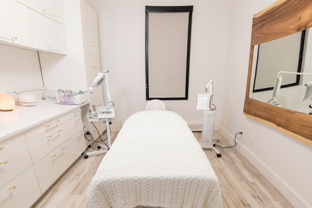 A calming beauty room showcasing a bed and mirror, ideal for enjoying a spa day in Aspen's July setting.