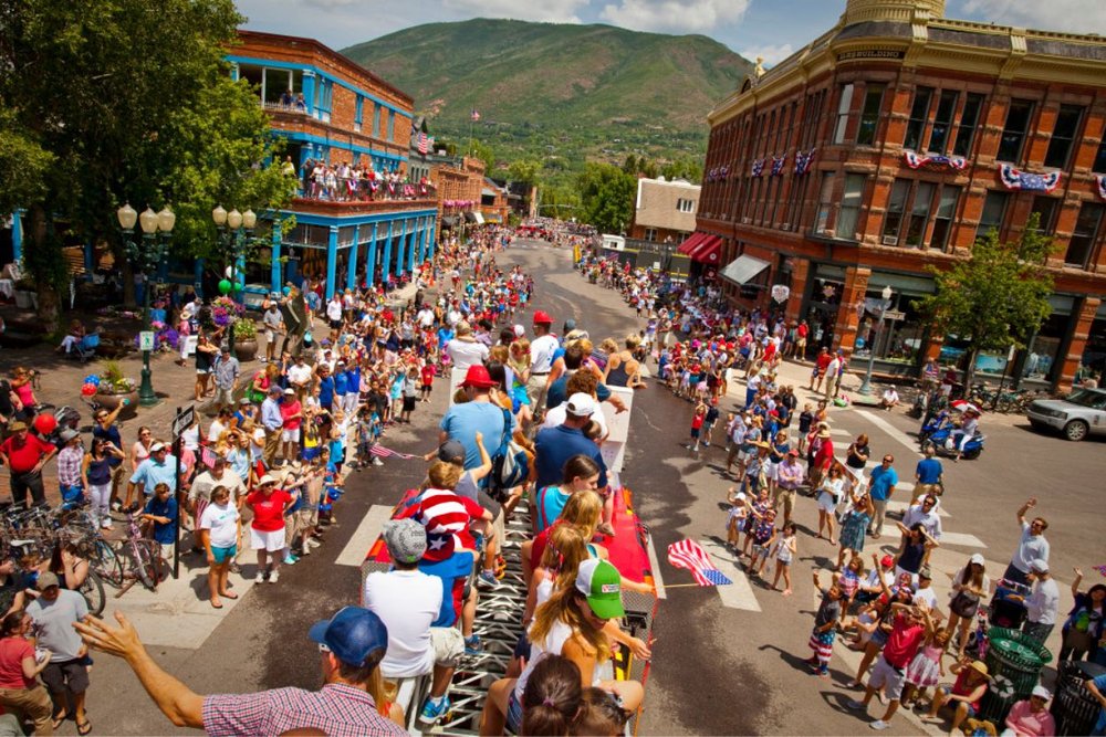 Vibrant 4th of July parade in Aspen with a crowd of people celebrating on the streets,