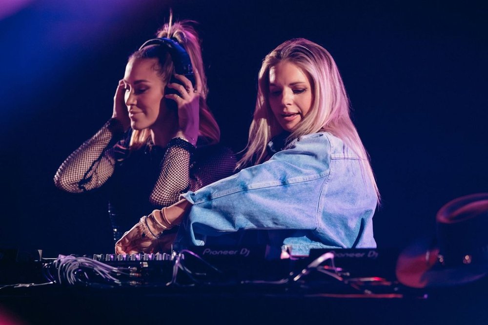 Two female DJs mixing tracks at a nightclub in Aspen in July