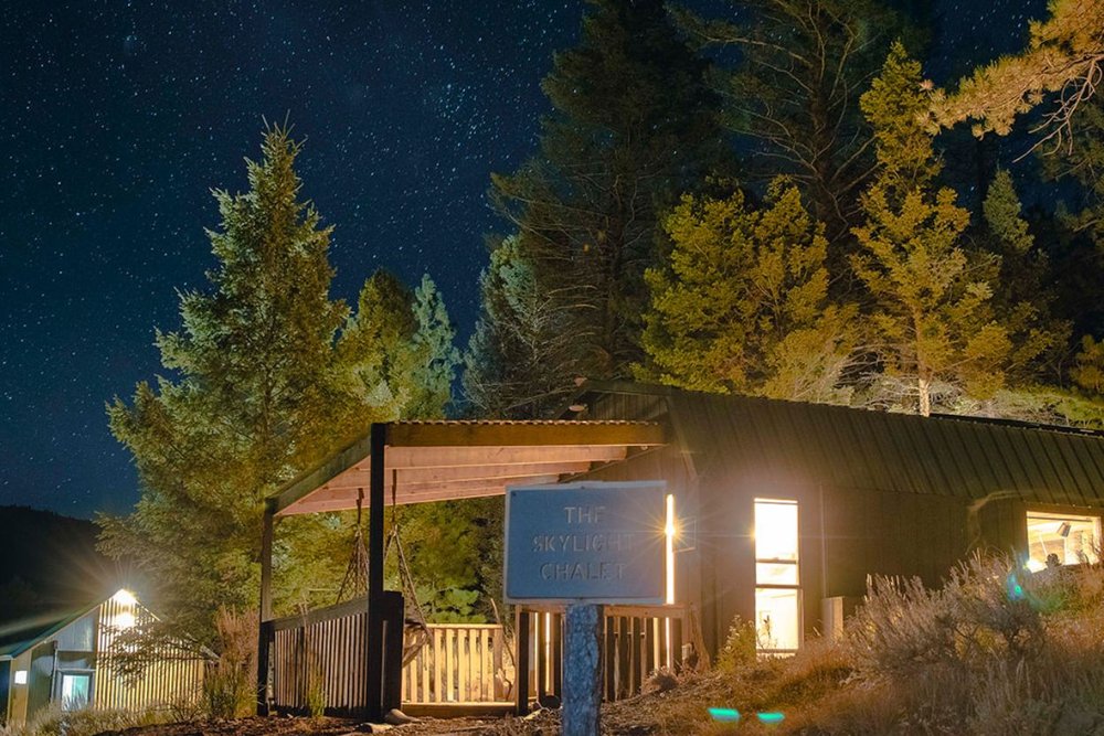 A serene cabin illuminated by stars, capturing the essence of Aspen in July