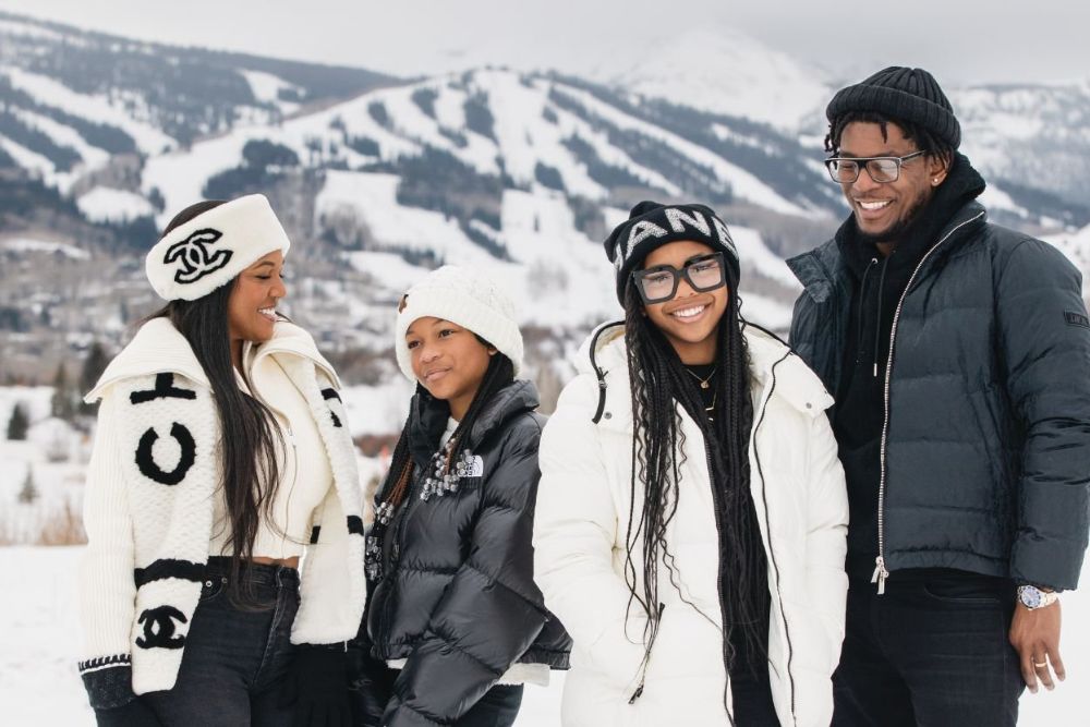 The family of tourist with their winter attire stand together, surrounded by a snowy landscape, enjoying the winter scenery.