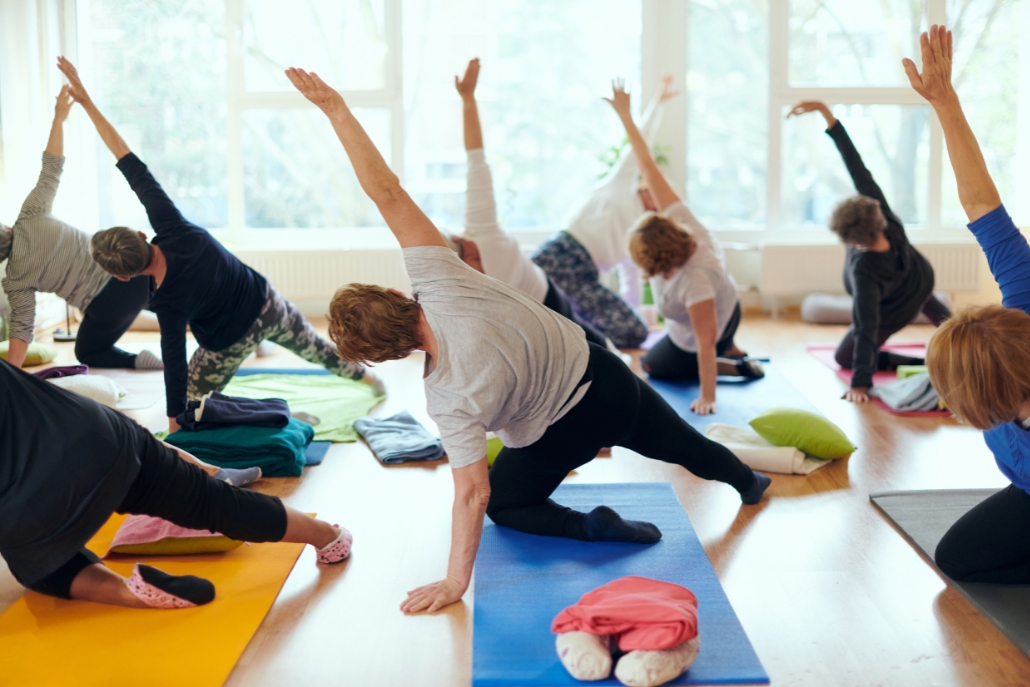 A participant in a yoga class at Arjuna Yoga, Yoga Aspen, showcasing accessible exercises for older adults.