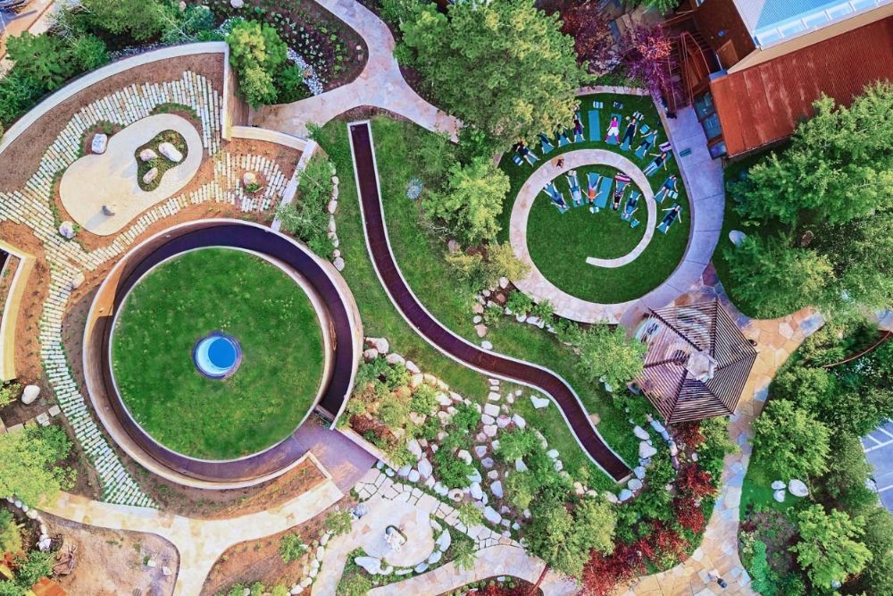 Aerial view of a circular garden featuring a group of people performing a yoga.