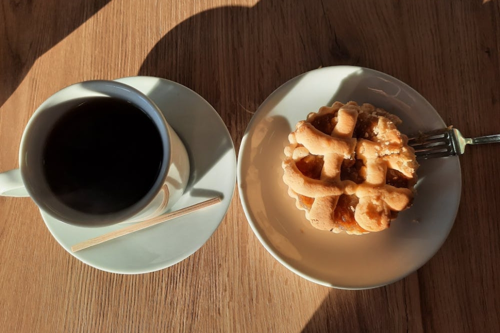 A slice of pie alongside a cup of coffee on a rustic wooden table at Aspen's Gorsuch Ski Café.