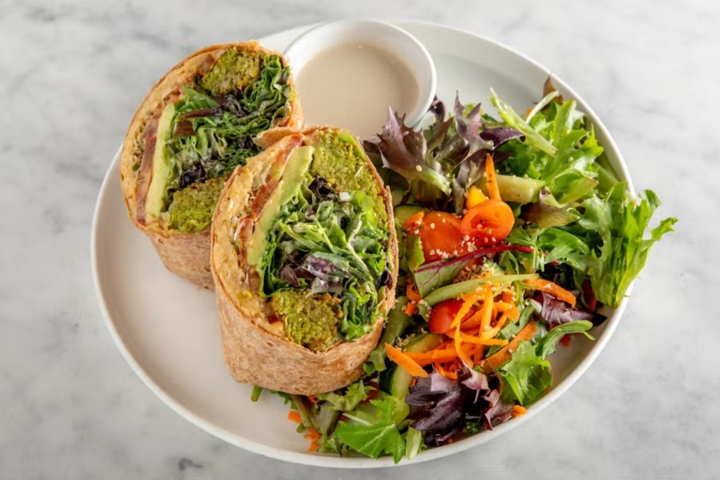 A vibrant vegetable and salad wrap displayed on a plate, showcasing the culinary offerings of Spring Cafe Aspen.