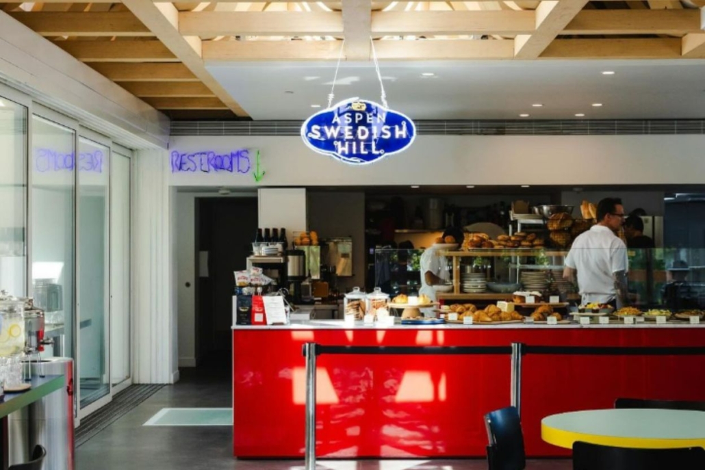 Inside the Swedish Hill Café featuring a vibrant red counter and a blue sign, showcasing the charm of Aspen Coffee Shops.