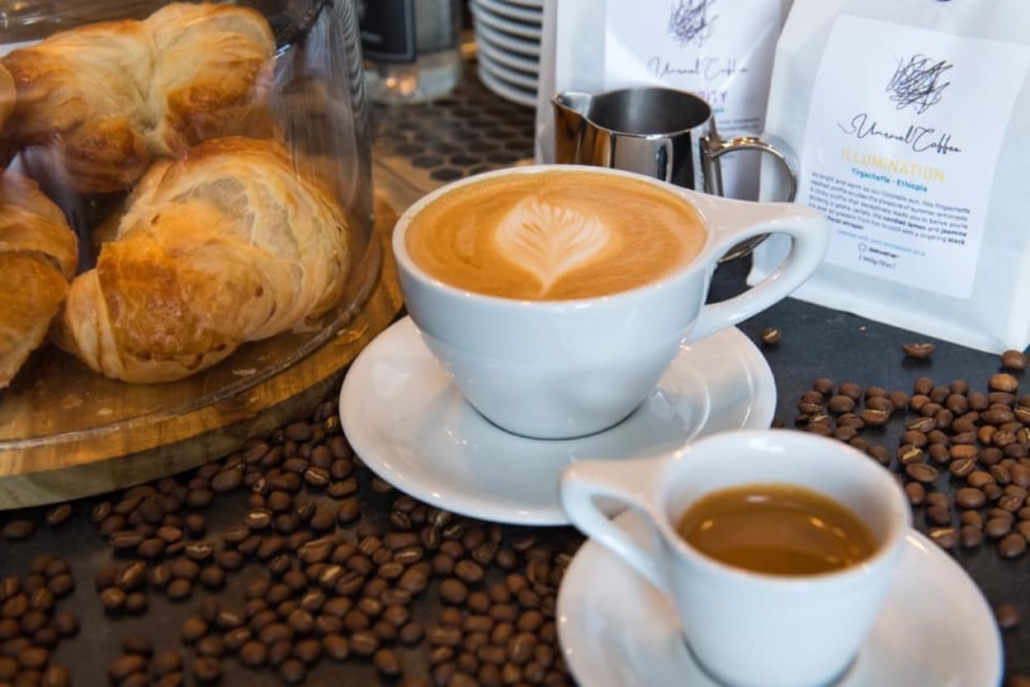 A close-up of coffee beans alongside freshly baked croissants, showcasing the inviting atmosphere of Aspen coffee shops.