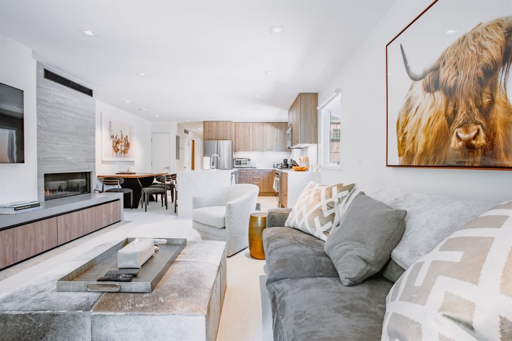 A charming Chalet Shanelle living room decorated for Christmas, showcasing a cow painting that adds character to the space.