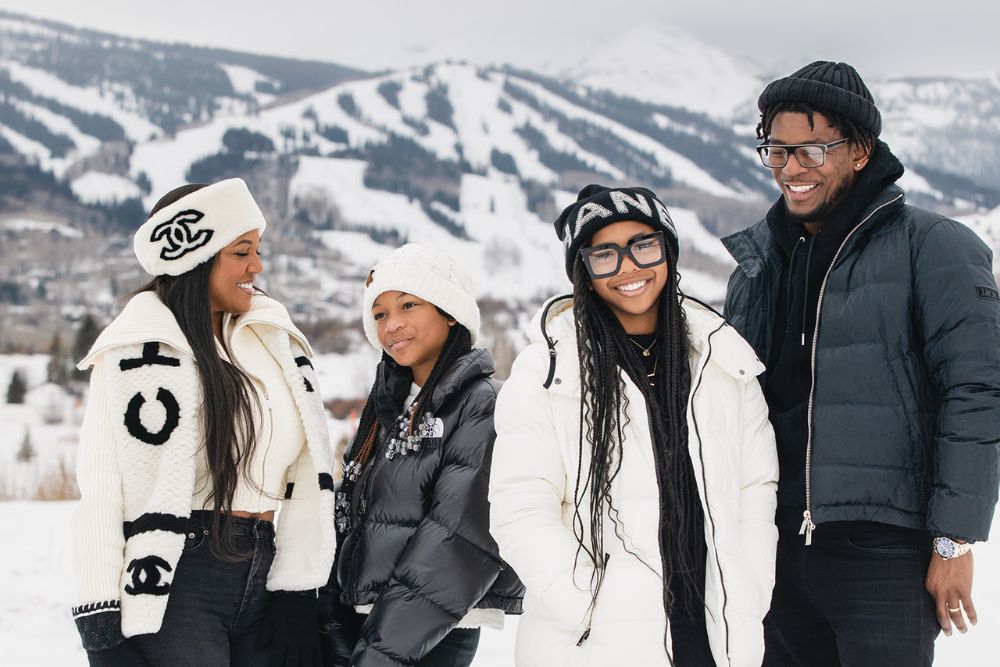 Family of tourist in cozy winter outfits happily posing for a photo, capturing the essence of Christmas in Aspen, Colorado.