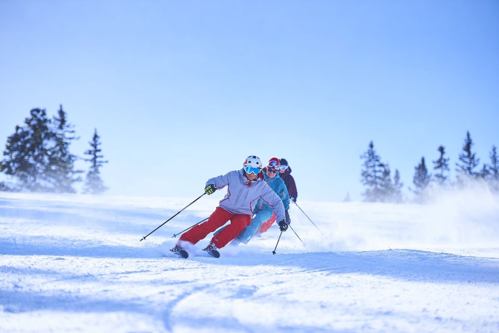 A group of skiers navigate a snowy slope in Aspen, Colorado, enjoying a festive Christmas ski tour experience.