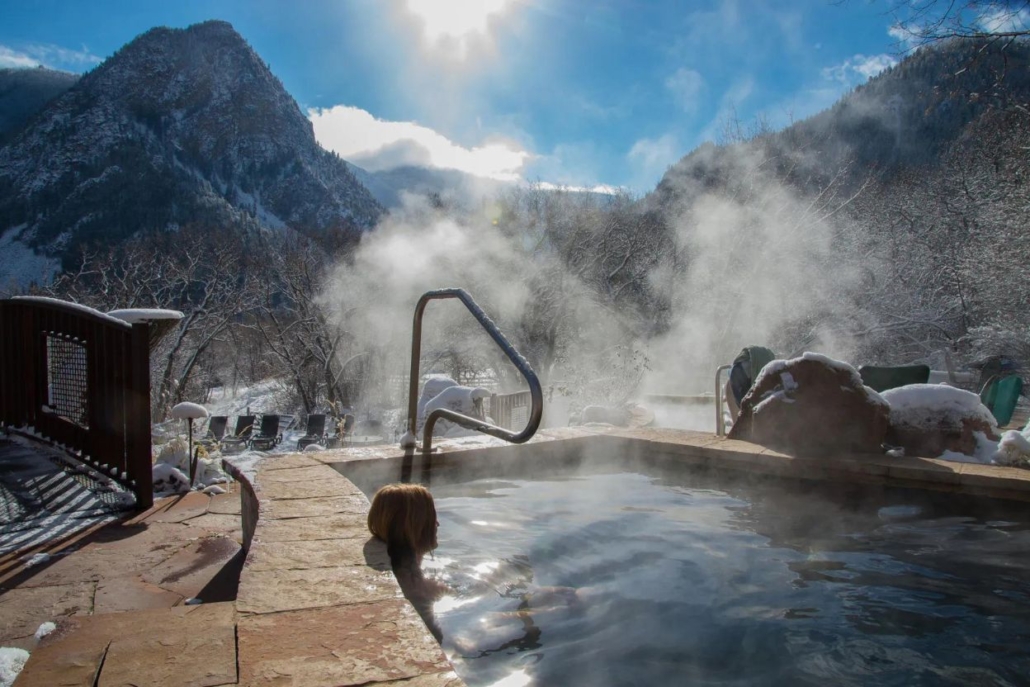 A steaming hot tub at Hot Springs Aspen, exuding warmth and comfort in a picturesque outdoor environment.