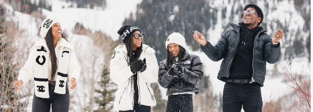 A family stands together in a snowy landscape, enjoying a winter day in Aspen, December.