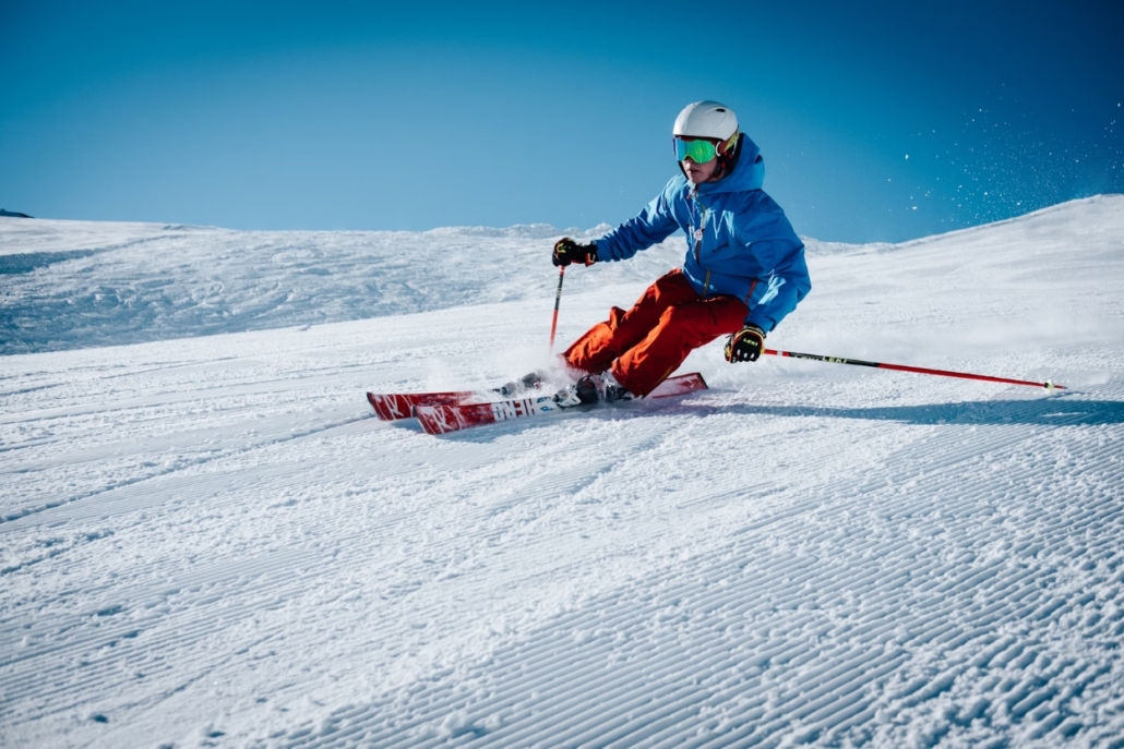 A skier glides down a pristine snowy slope, capturing the essence of winter sports in Aspen's December scenery.