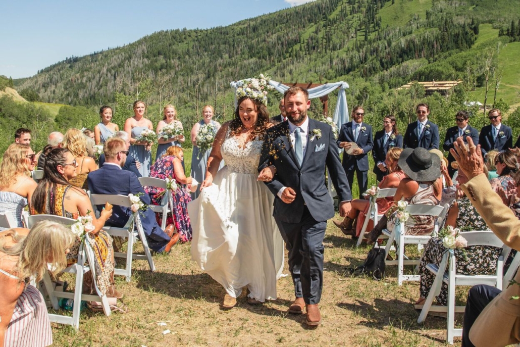 The bride and groom joyfully walk down the aisle at their wedding ceremony in the John Denver Sanctuary.