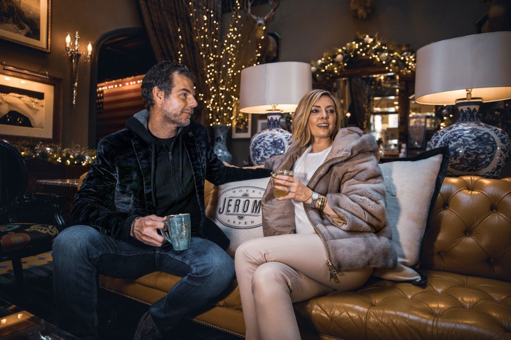 A couple enjoys each other's company on a couch in a stylish hotel room at Hotel Jerome, Aspen.