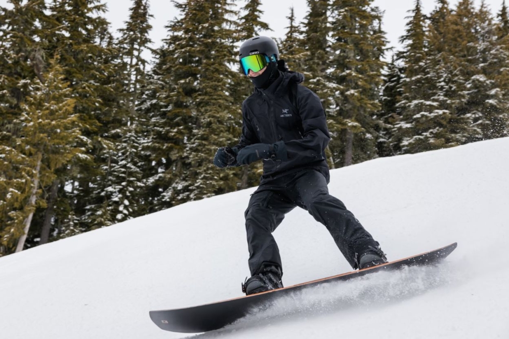 A person skillfully rides a snowboard down a snowy slope at Aspen Mountain, capturing the essence of luxury winter sports.